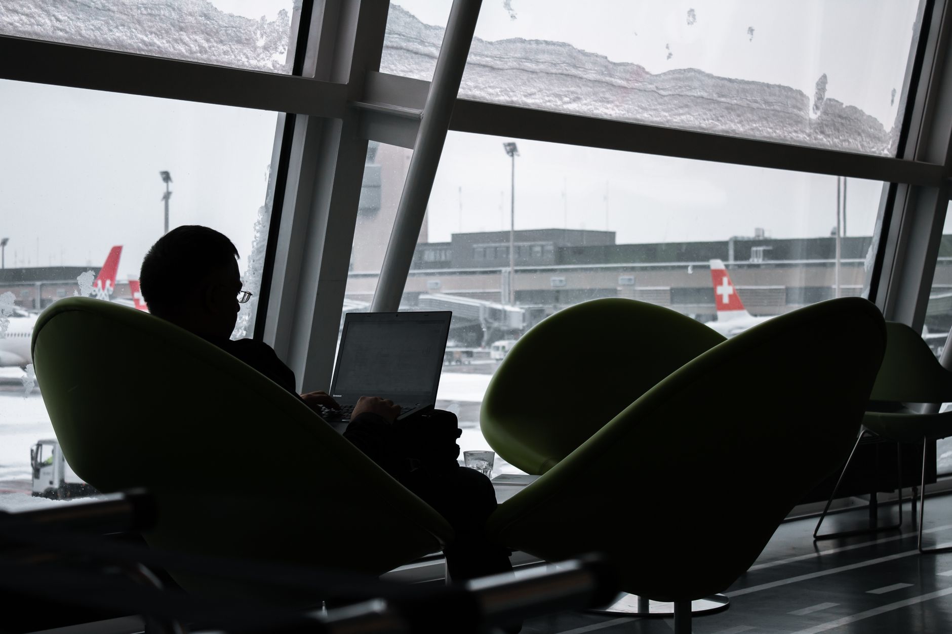 A traveller waiting by the window in an airport terminal