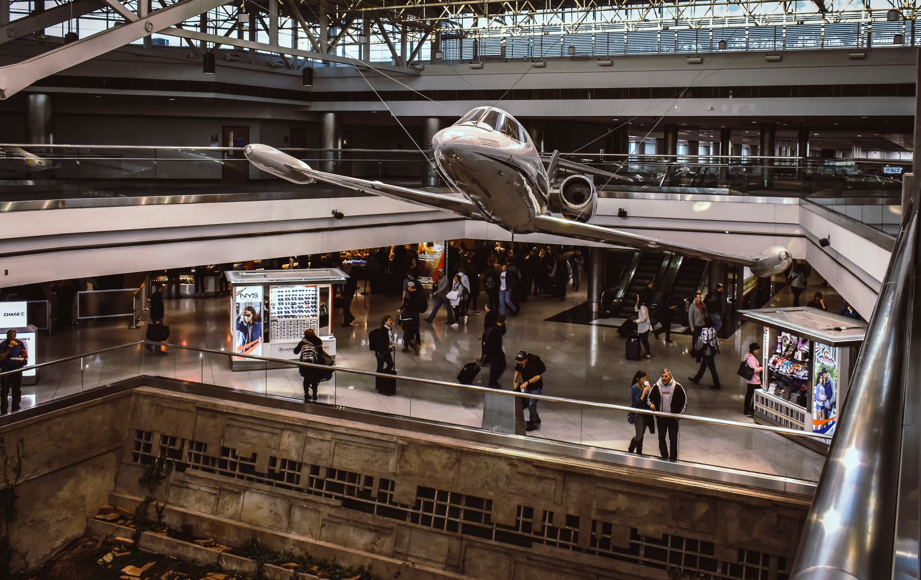 Travellers and retail kiosks in a busy airport terminal hall